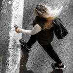 Kvinna sneddar över gata, sedd uppifrån