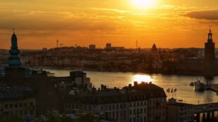 Vy i solnedgång över Stockholms innerstad, stadshuset till höger.