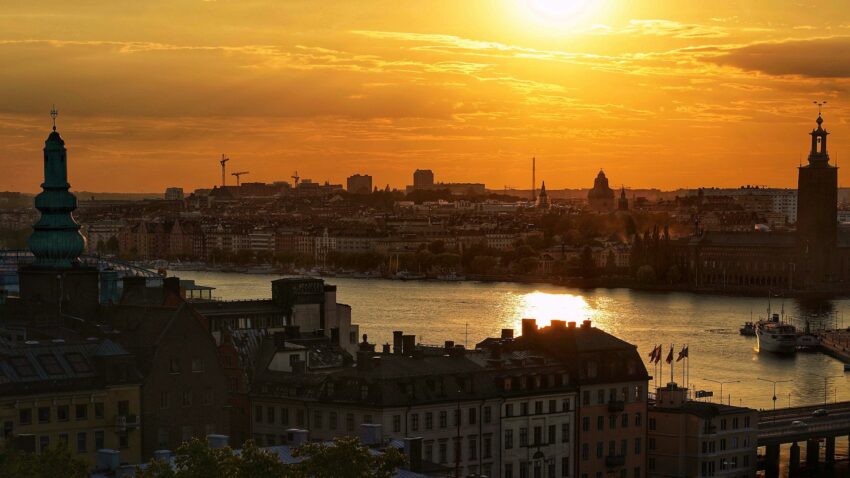 Vy i solnedgång över Stockholms innerstad, stadshuset till höger.