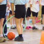 Barn med boll och hoppring i en gymnastiksal.
