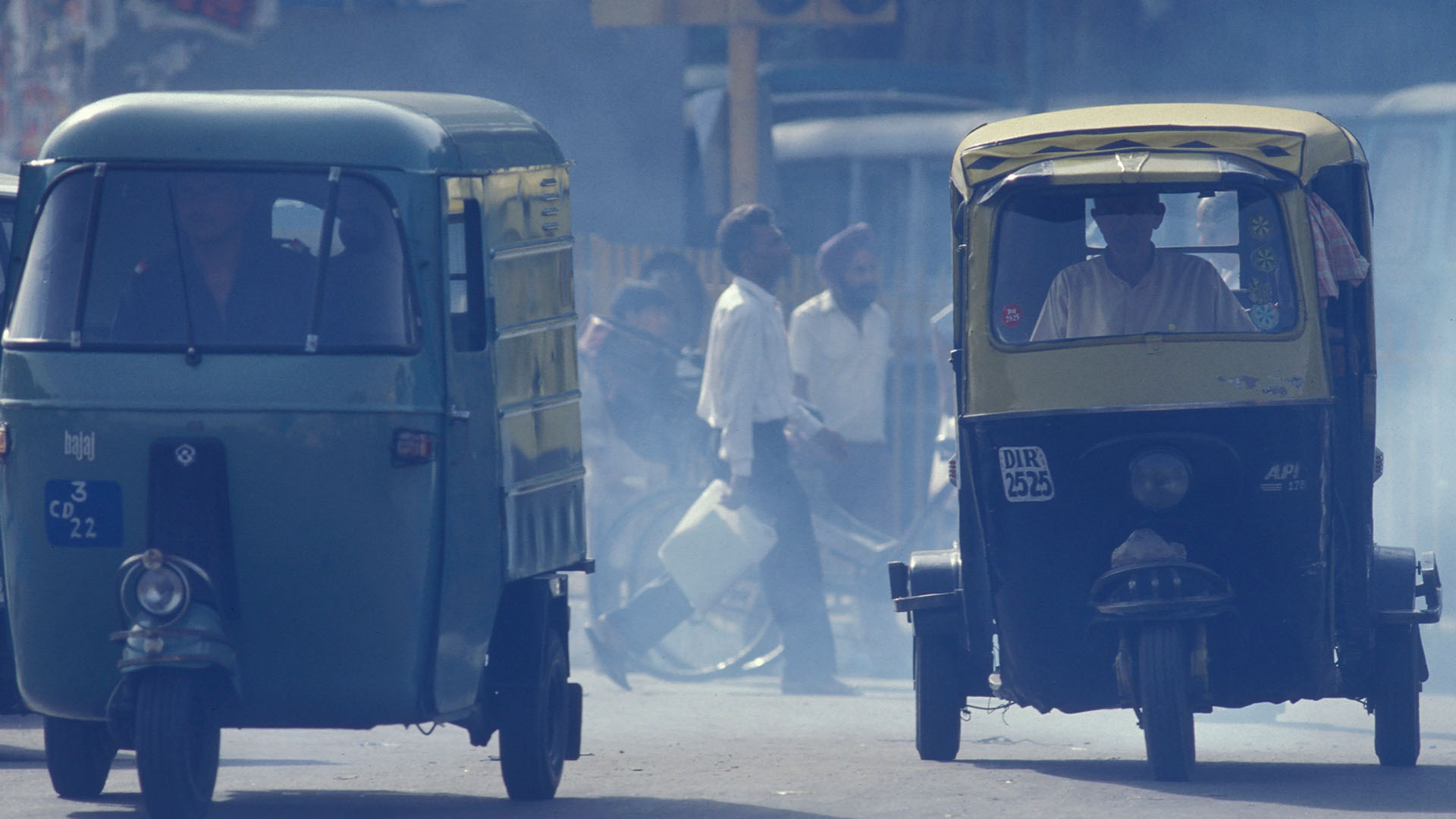 Människor korsar en trafikerad gata i Indien.