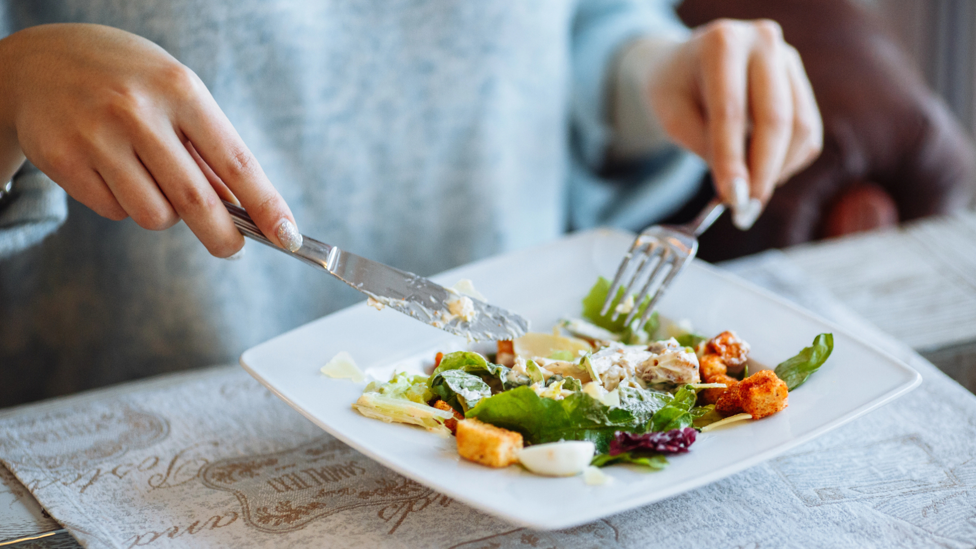 En ung kvinna äter caesarsallad.