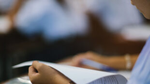 Studerande läser från ett papper.