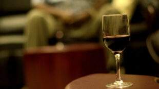 Ett glas vin på en pall framför soffa.