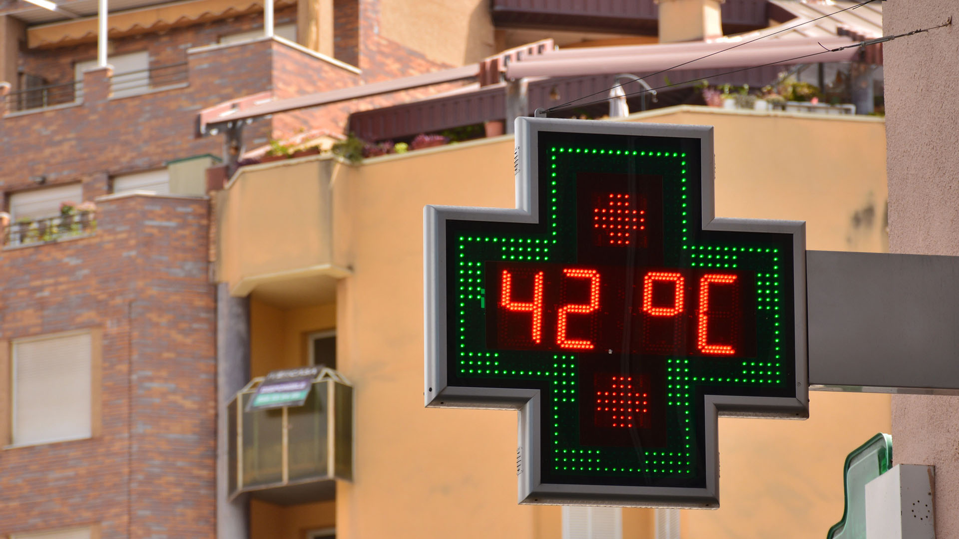 Skylt framför hus visar 42 grader celcius.