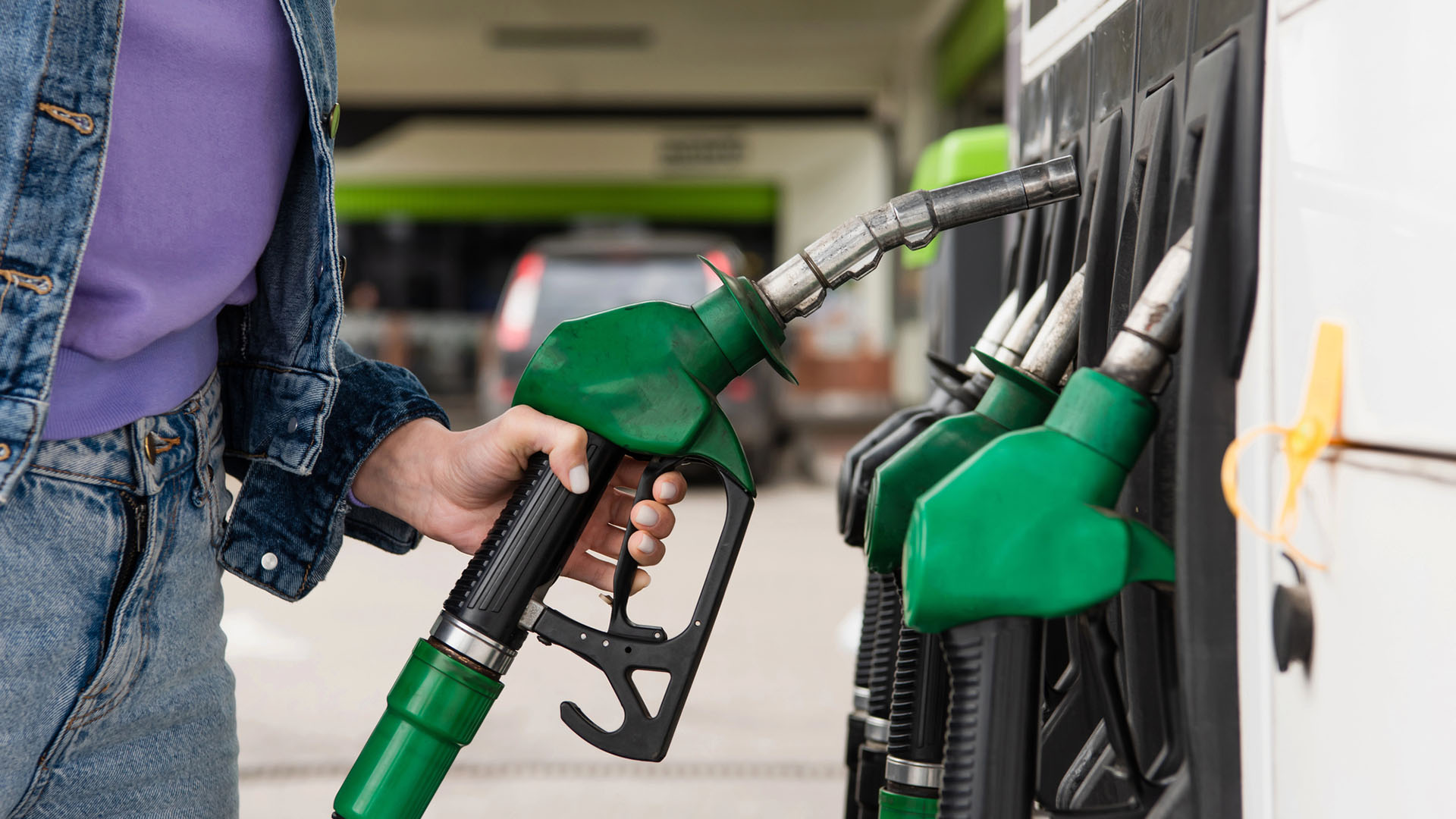 Kvinna tankar bilen på en bensinmack.