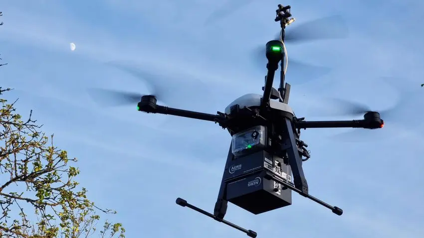 En svart drönare surrar i luften