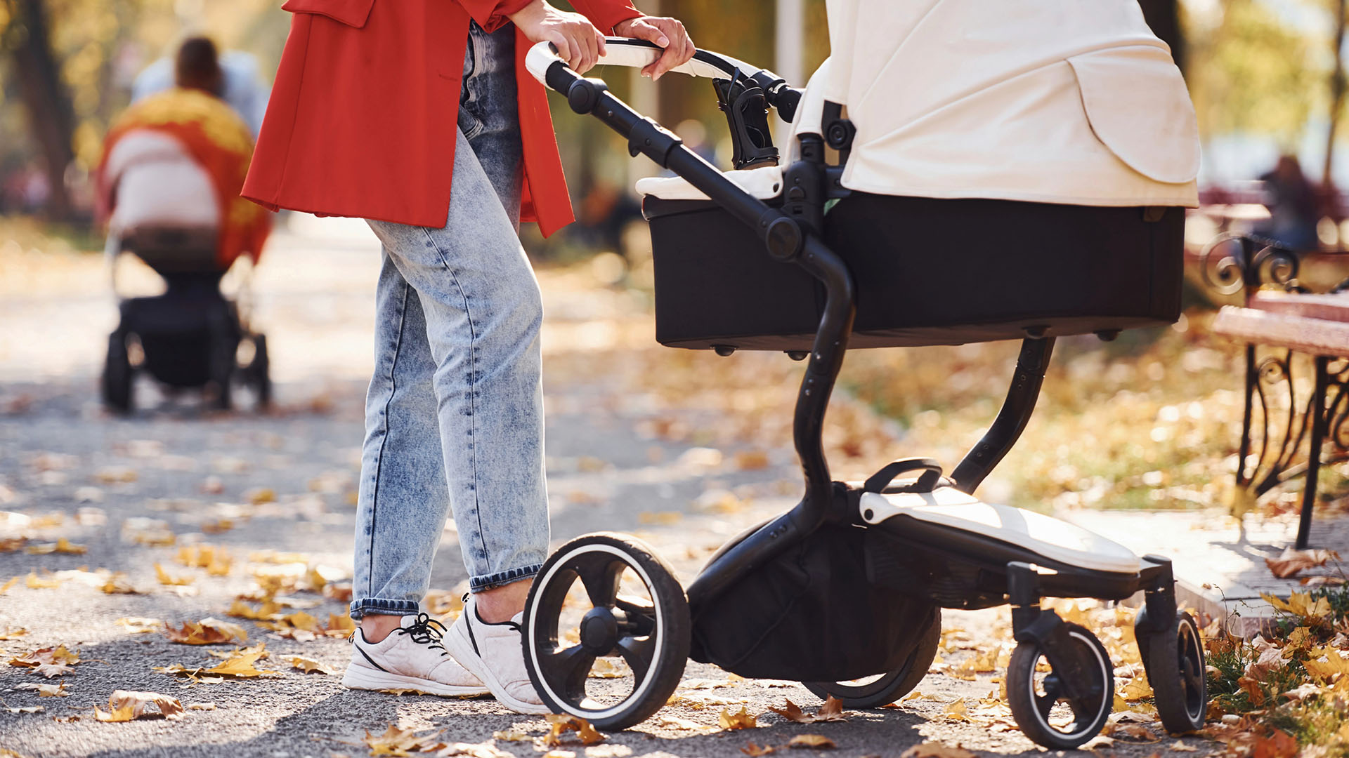 Kvinna med röd kappa med barnvagn