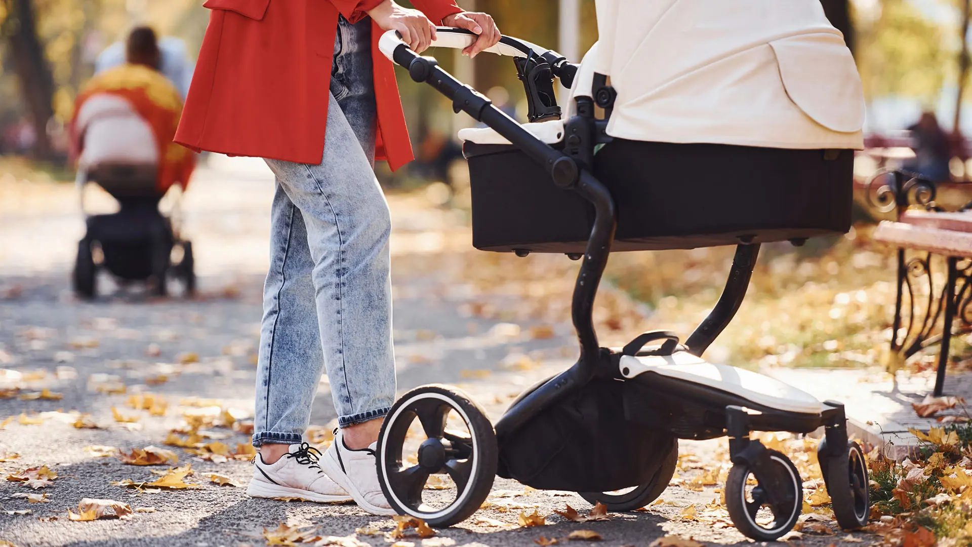 Kvinna med röd kappa med barnvagn