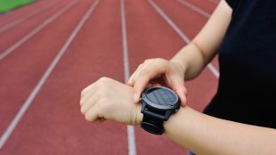 Friidrottare kollar en träningsklocka.