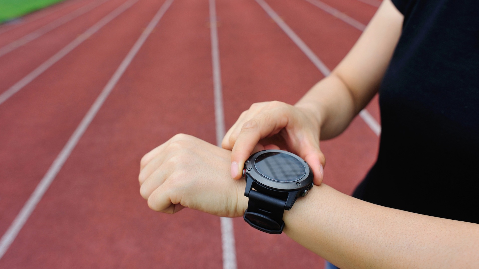 Friidrottare kollar en träningsklocka.