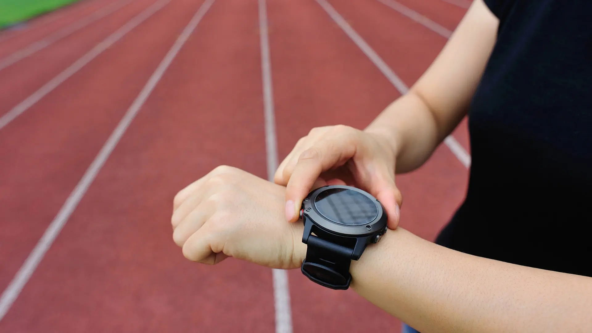Friidrottare kollar en träningsklocka.