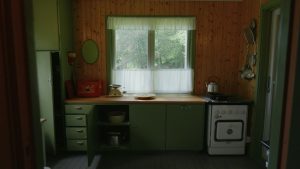 Grönt, gammalt, kök i stuga.