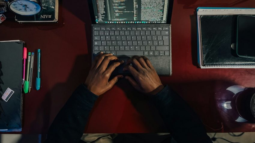 Två händer på en laptop, sett uppifrån.