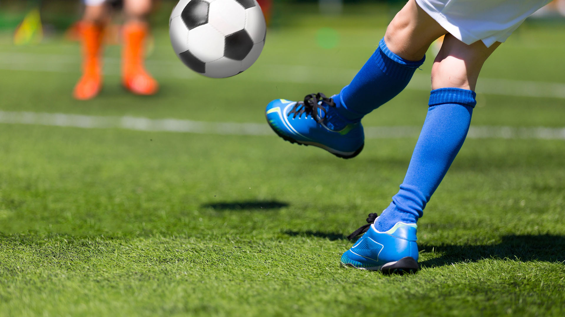 Barn spelar fotboll.