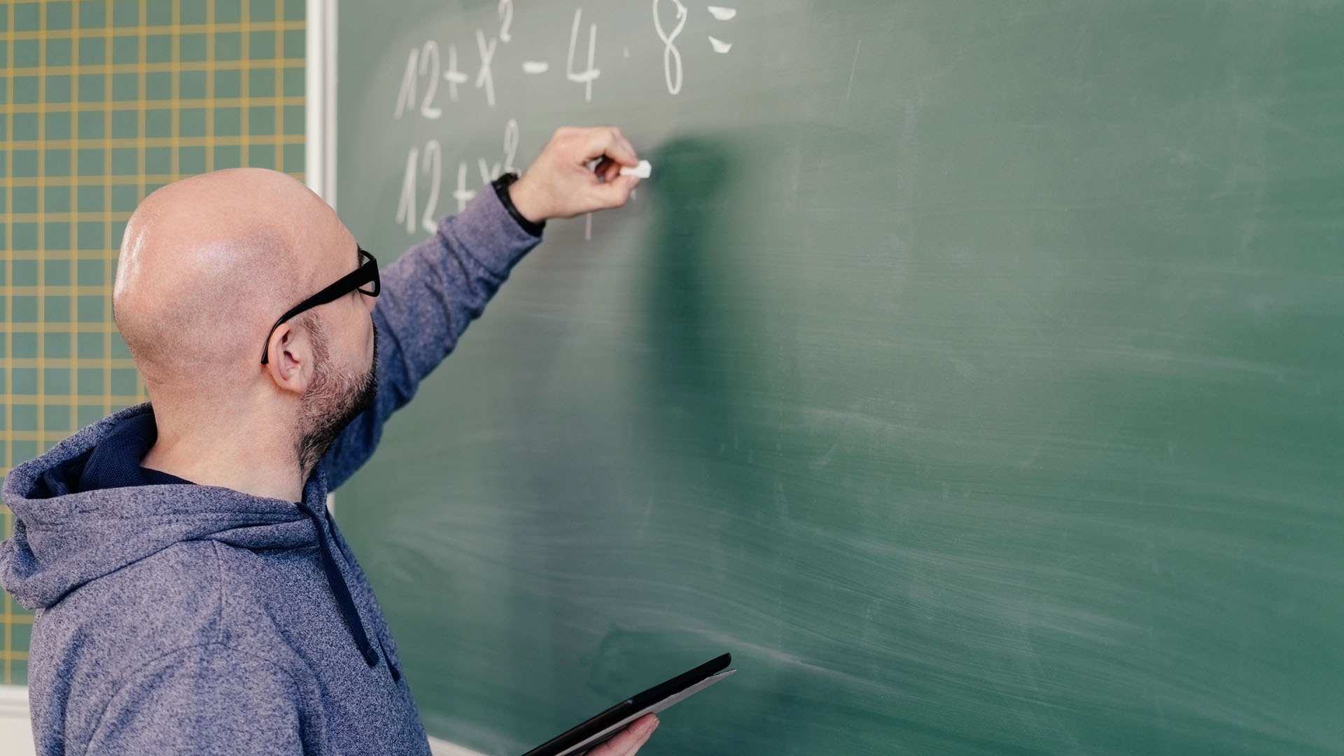 Lärare skriver tal på tavla.