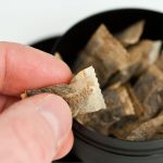 Hand tar snusprilla ur snusdosa.