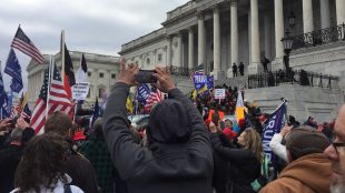 Folksamling utanför Kapitolium, USA. Många flaggor i luften.