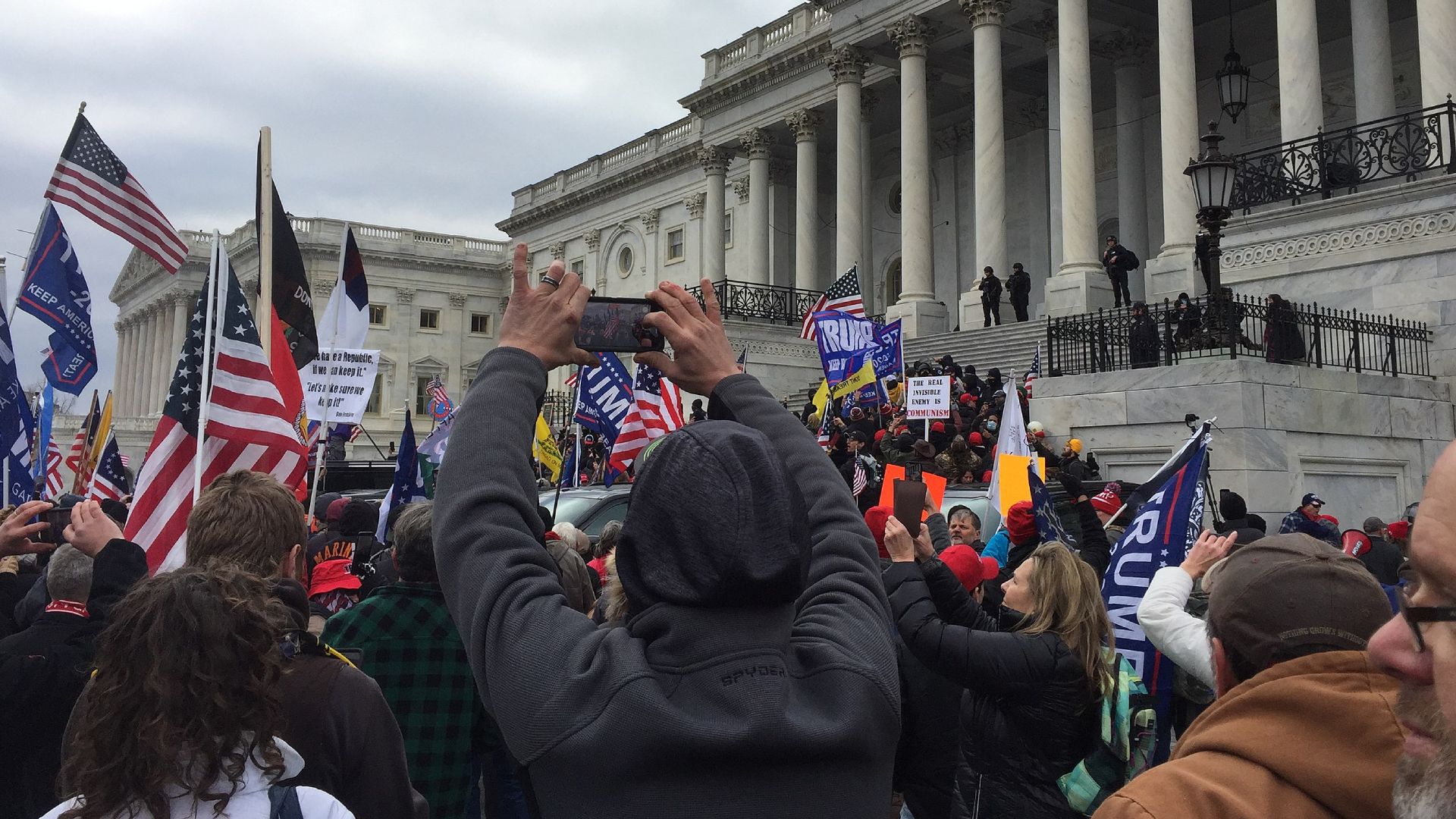 Folksamling utanför Kapitolium, USA. Många flaggor i luften.