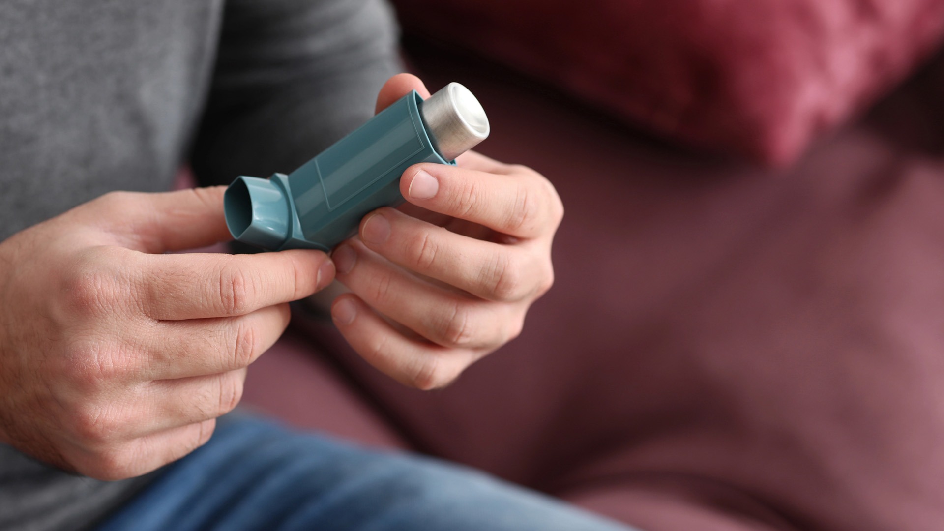 Man håller en astmasprej i händerna.