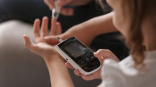 Förälder mäter glukosvärde på barn.