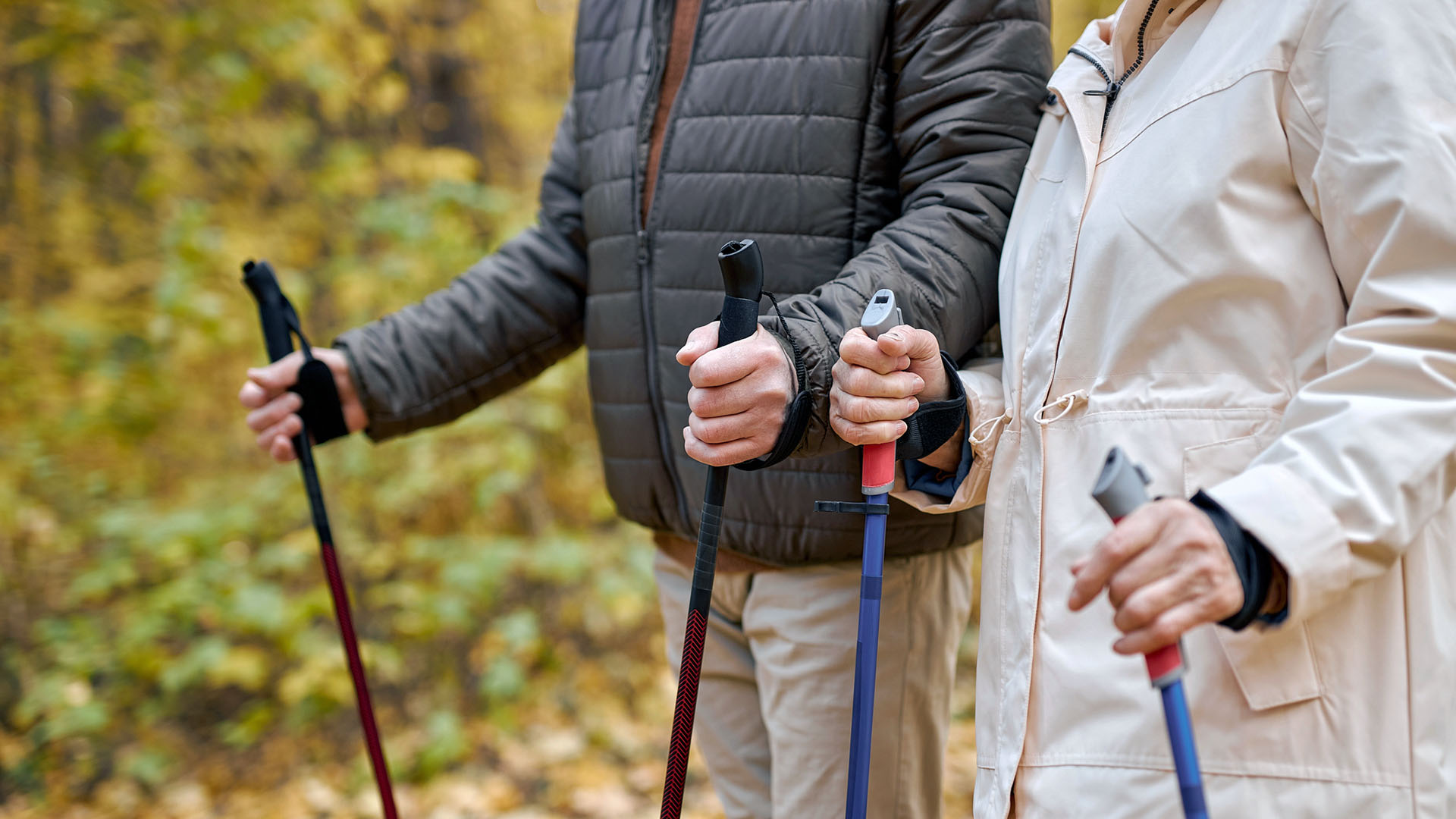 Ett äldre par promenerar med stavar.