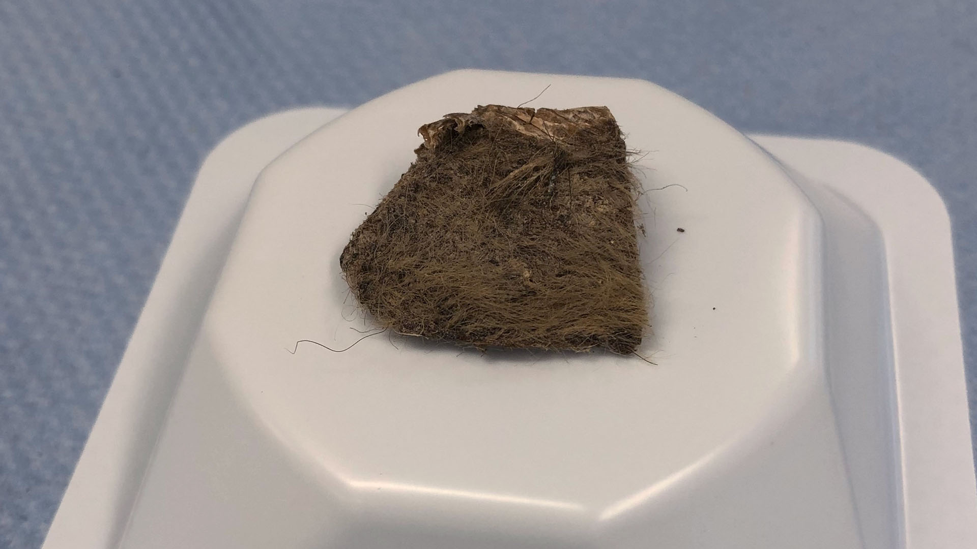 En fyrkantig bit ullig vävnad på en låda