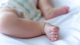 Bebisfötter i säng.