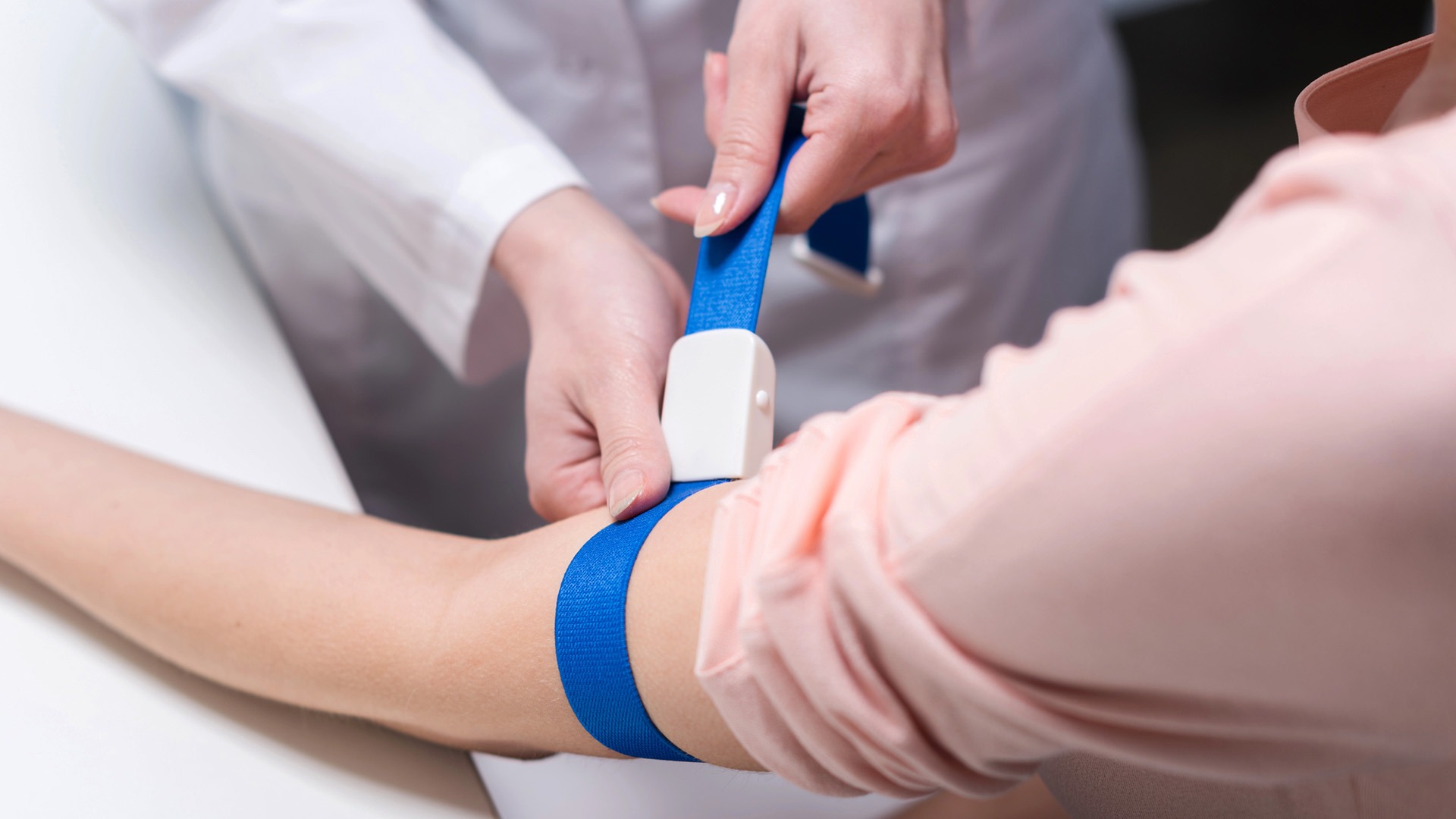 Förberedelser med stasband inför blodprovtagning.