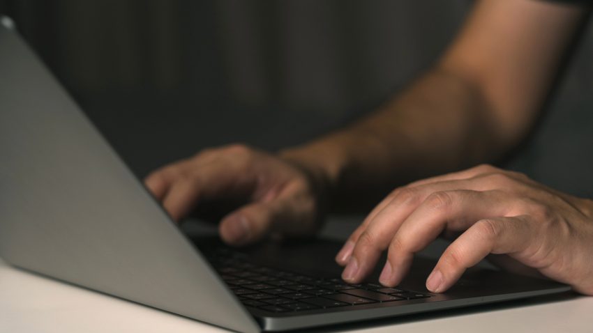 Man skriver på en dator.