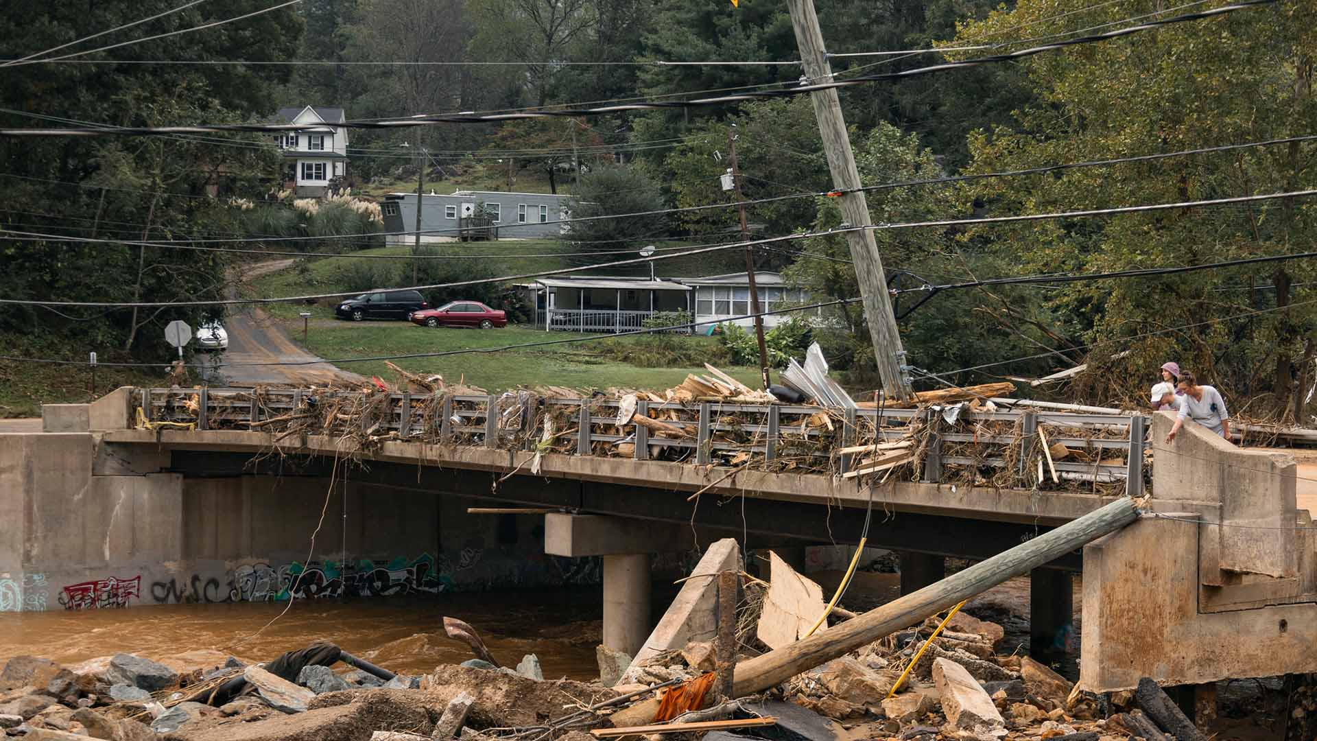 Skadad bro över flod och svajiga elledningar.