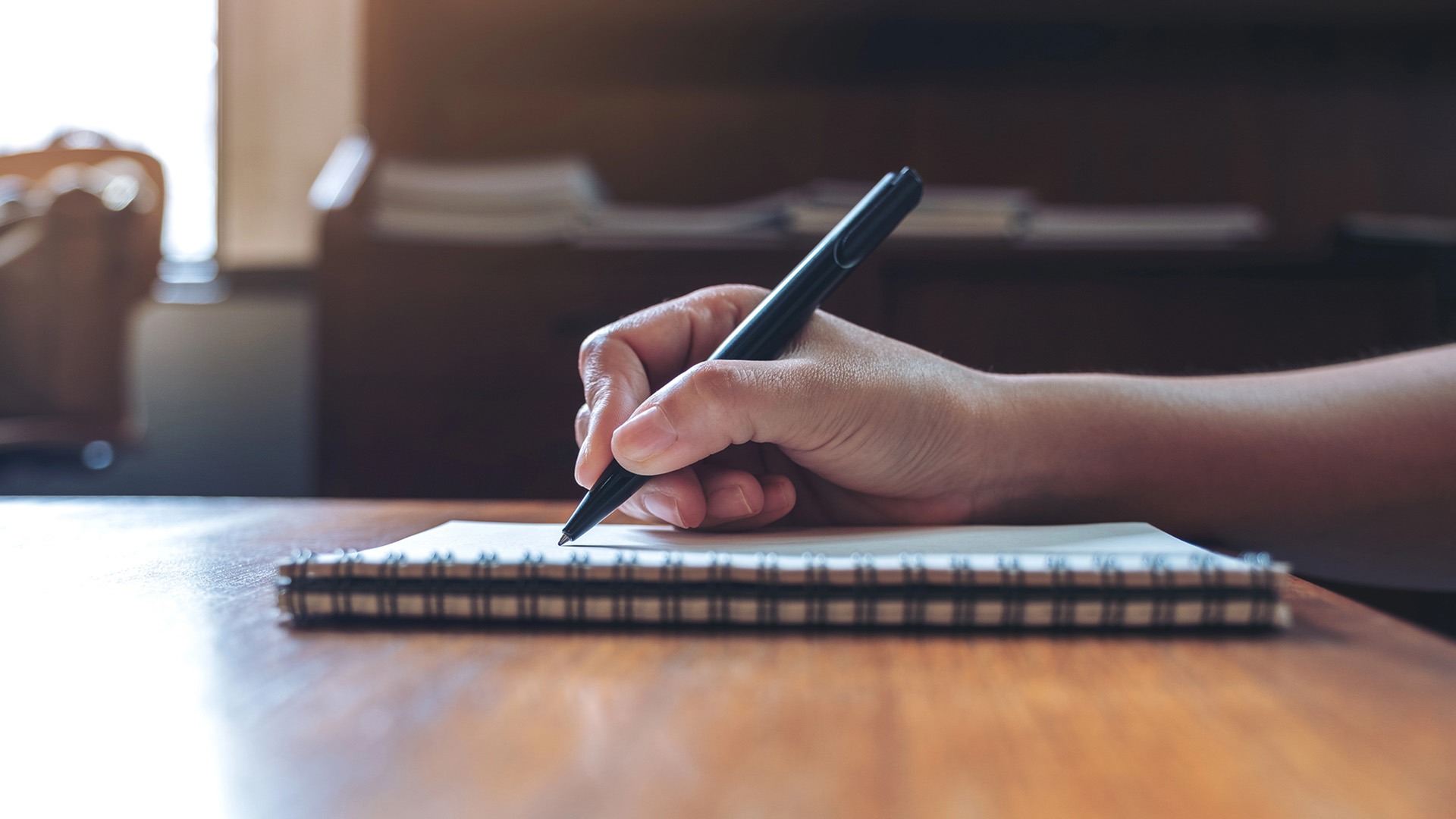 Person skriver i ett anteckningsblock