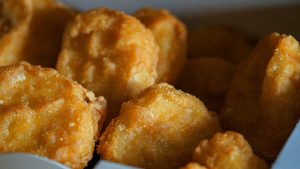 Bruna chicken nuggets, friterade, på fat.