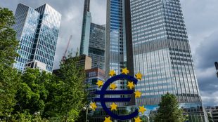 Skyskrapor med skylt med euro-tecknet framför.