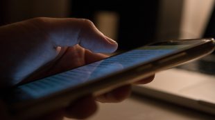 Man läser på mobilskärm.