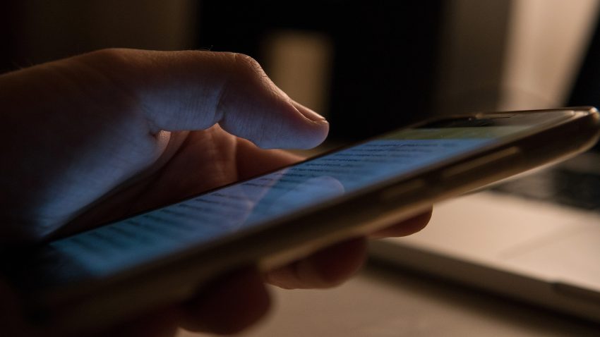 Man läser på mobilskärm.