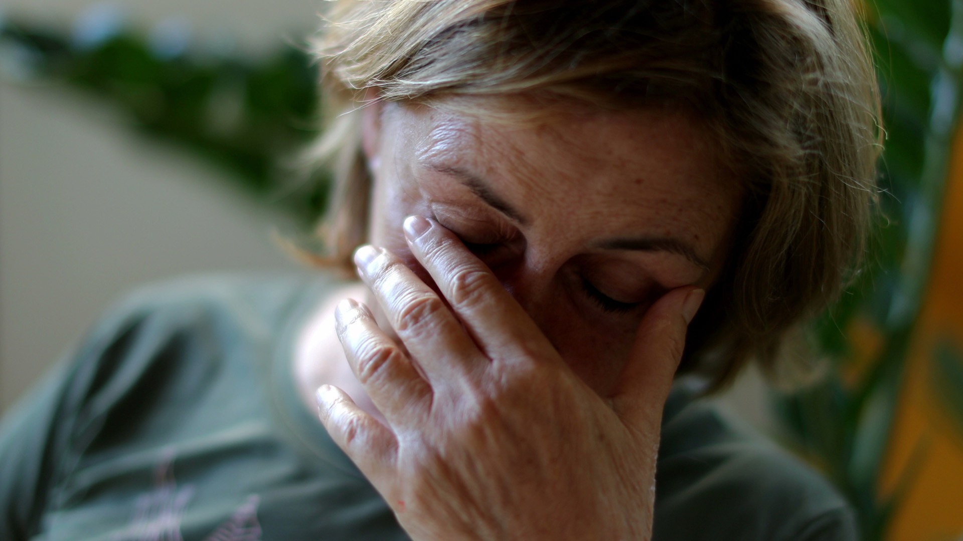 Kvinna håller händerna över ansiktet.