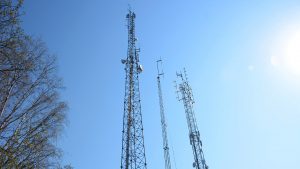 Tre radiomaster mot blå himmel.