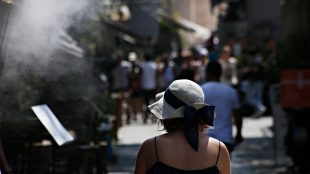 Kvinna i solhatt på gata.