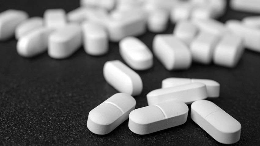 Tabletter på ett svart bord.