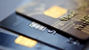 Tre kreditkort ligger ovanpå varandra, närbild.