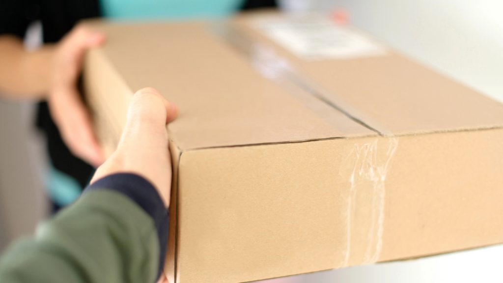 Paket överlämnas från bud till köpare.