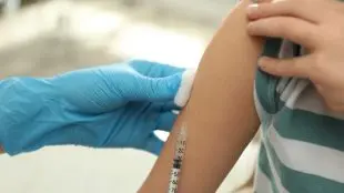 Pojke i randig tröja vaccineras