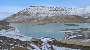 Liten glaciärsjö omgiven av berg.