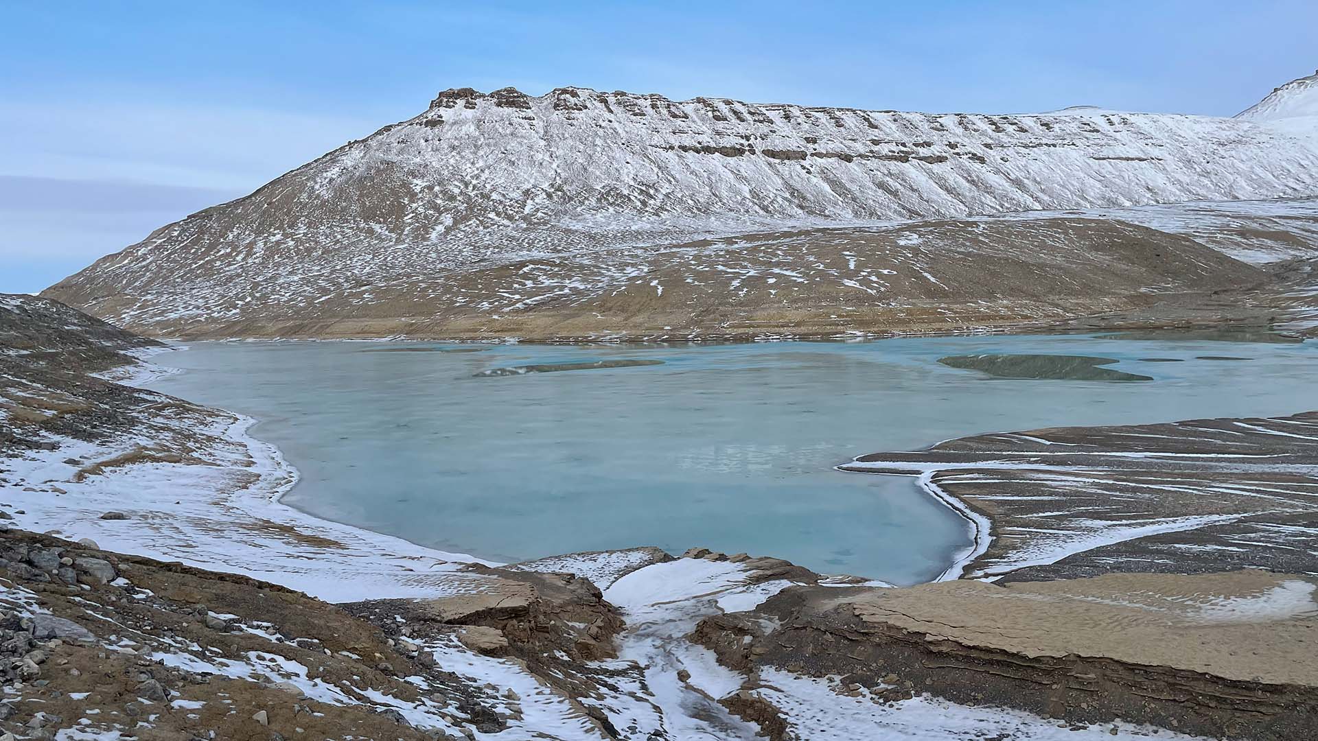 Liten glaciärsjö omgiven av berg.