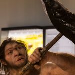 Neandertalare med ett spjut i en fisk