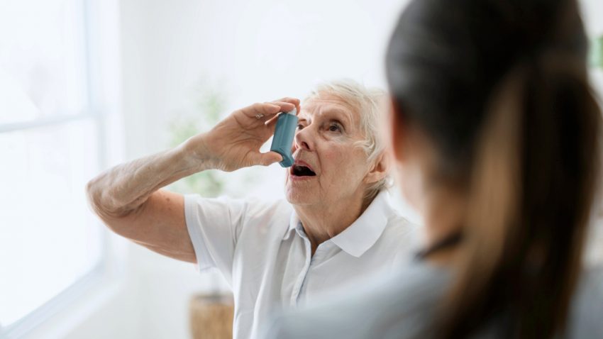 En sjuksköterska hjälper en kvinnlig kol-patient att inhalera med sin inhalator.